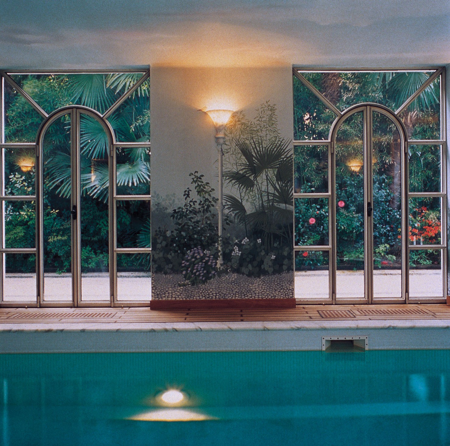 A pool facing a florid garden - استخر های شنا