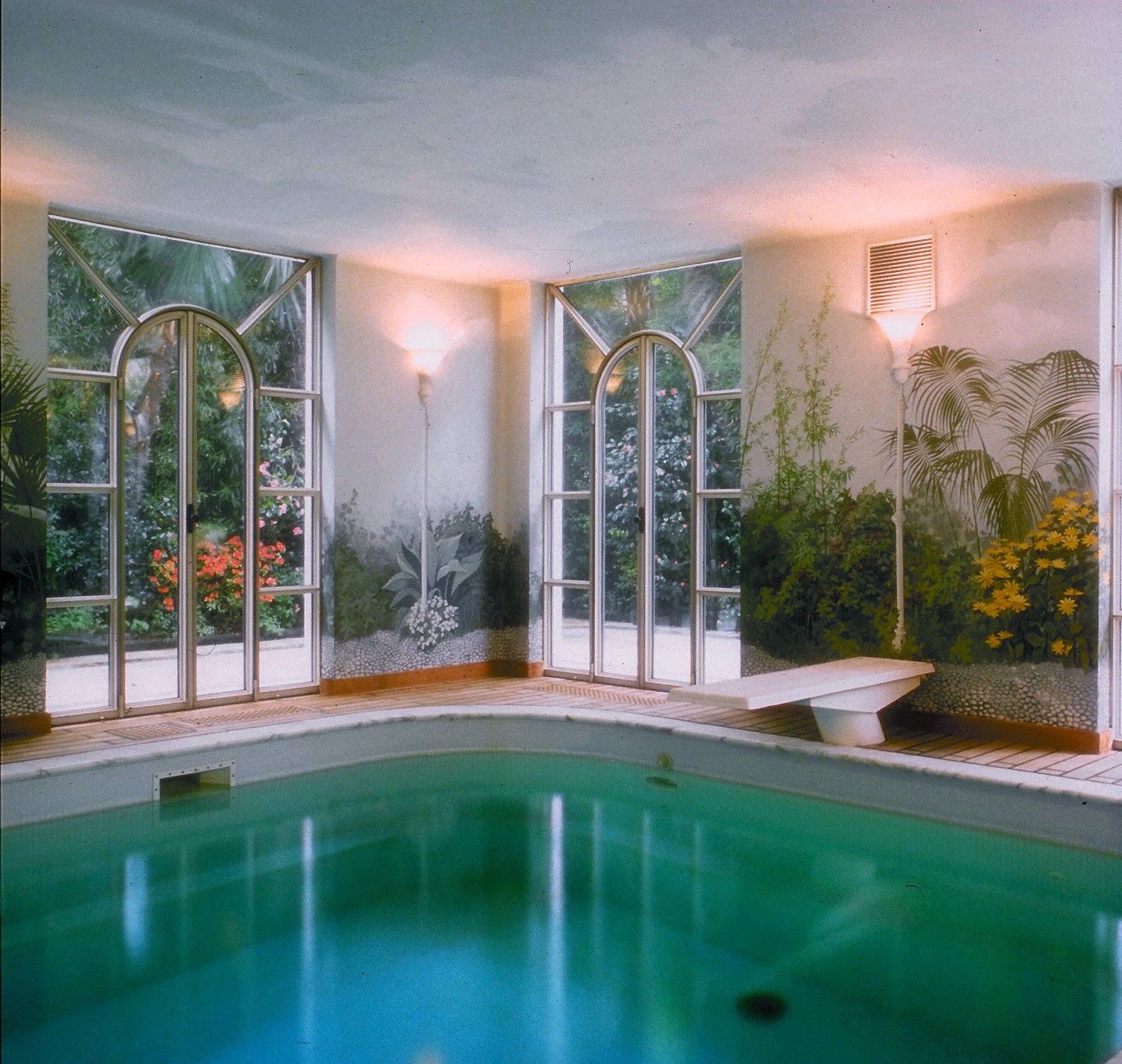 A pool facing a florid garden - استخر های شنا